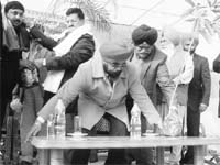 Punjab Transport Minister Master Mohan Lal gives a sapling to a participant during a traffic safety week in Mohali on Monday. 
