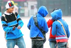 Young cobblers enjoy a light moment at the Sector 17 Piazza, as chilly conditions prevail in Chandigarh on Monday. 
