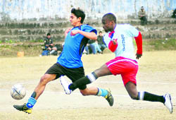 The players try to take control of the ball in a match of the Great Vivekanand Memorial Football Tournament in Dehradun on Monday