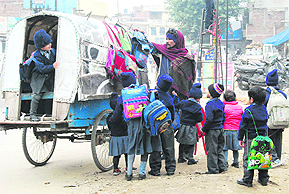Tinytots brave the early morning chill en route to school in Ludhiana on Monday.