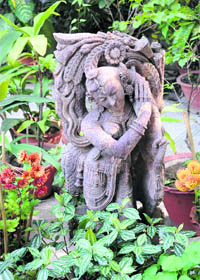 the stone statue nestles in greenery