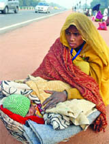 A labourer protects her child from the intense cold in New Delhi on Tuesday.
