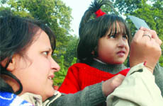 A child along with her mother sees partial solar eclipse at Nehru Planetarium in New Delhi on Tuesday.