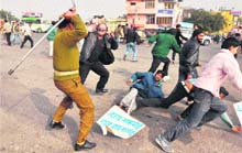 A policeman cane-charges activists of the PDP protesting against the price rise at Bikram Chowk in Jammu on Tuesday. 