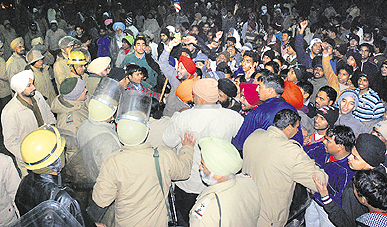 Residents of Burail block the road at the Sector 45 lights in Chandigarh on Wednesday.