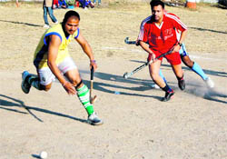 Players vie for the ball during a match in the District Hockey League Championship in Dehradun on Wednesday