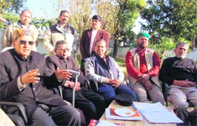 BD Raturi, former president of the UKD, addresses the media as expelled party minister Diwakar Bhatt (extreme right) looks on in Dehradun