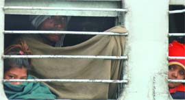 A passenger and his children wrap themselves in warm clothes in a train to protect themselves from the intense cold in New Delhi on Wednesday.