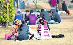 Girls enjoy sunshine after days of foggy weather on the Jammu University campus