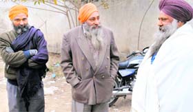 Senior citizens wait outside one of the police stations in Patiala
