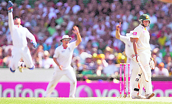 Michael Clarke (L) reacts after being dismissed and (Above) English players celebrate the wicket of Usman Khawaja in Sydney on Thursday.