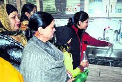 People assemble at the house of Rajesh Arora to collect hot water
