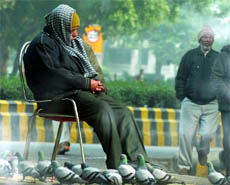 An elderly man enjoys sunshine on yet another chilly day in New Delhi on Friday.