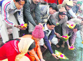 People offer flowers to the Ganga to pay tributes to the victims of the Mussoorie