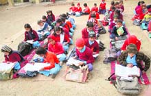 Children sit on mats in a government school in Jammu.