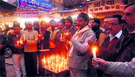 Traders light candles in the memory of bus accident victims at Sabji Mandi in Haridwar on Saturday.
