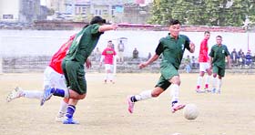 Players vie for the ball in a match of the Great Vivekanand Memorial Football Tournament in Dehradun on Saturday.