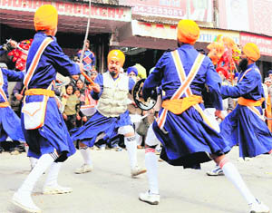 Youths play gatka during a procession held as part of the birth anniversary celebrations of Guru Gobind Singh in Karnal on Saturday.