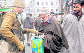 A CRPF jawan checks the bag of a commuter at Lal Chowk in Srinagar on Saturday.