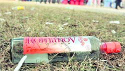 A liquor bottle thrown near the playing arena. 
