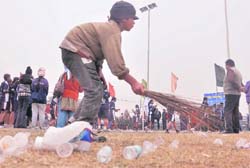 A boy sweeps the littered ground at the PAU, Ludhiana, on Sunday