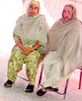 Two women wait for revenue officials near the venue of the sangat darshan programme at Sihar, near Ahmedgarh, on Sunday