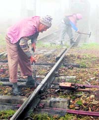 Railway employees work under freezing conditions near Amritsar railway station on Sunday.