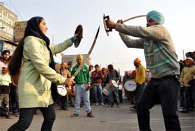 Devotees perform during a colourful and lively procession on the eve of Gurpurb in Gurgaon on Monday.