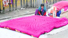 CHILD LABOUR: A girl stitches a quilt near Meeta Ghati Chowk in Karnal
