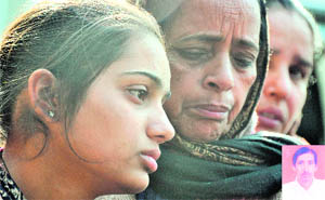 Grief-stricken Heena, daughter of Ramesh Kumar (inset), with her relatives in Ludhiana on Monday.