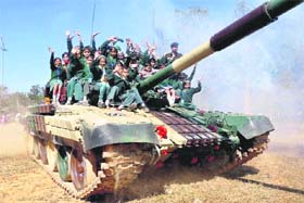 School students take a joy ride on top of an Indian Army T-72 battle tank during the 'Know Your Army' exhibition at Morabadi Ground in Ranchi, Jharkhand, on Monday. 