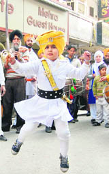 A child takes part in a nagar kirtan procession  organised on the eve of the birth anniversary of Guru Gobind Singh in Amritsar on Monday. 