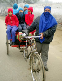 Braving the cold weather, kids go to school in Bathinda on Monday morning.