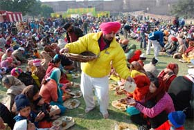 Devotees partake of langar organised on the occasion of the birth anniversary of Guru Gobind Singh at Gurdwara Qila Mubarik Sahib in Bathinda