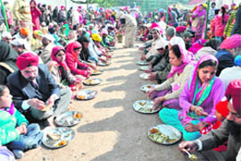Devotees take part in a langar on Guru Gobind Singh’s birth anniversary at the Sector 34 gurdwara in Chandigarh