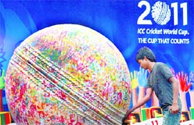 A cricket fan puts his hand print on a giant cricket ball during an event held in conjunction with the Cricket World Cup in Colombo