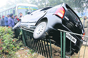 A Maruti Alto astride a median railing after colliding with a bus on the road dividing Sectors 22 and 33 in Chandigarh on Wednesday.