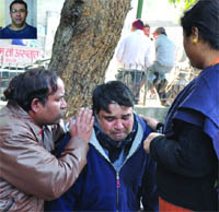 Relatives of Rajiv Jolly Wilson (inset), the victim in the case, console each other outside t