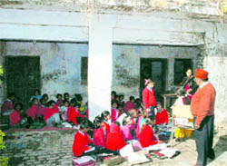 Students of primary school at Mansinghwala attend a class in the open due to the dilapidated condition of their school building