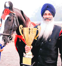 Satpal Singh of Johal village in Jalandhar stands near the champion horse with the trophy won at the National Livestock Competition in Muktsar on Wednesday.