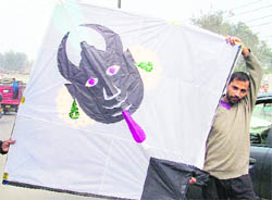 A man carries an 8-foot long kite with a devil face on Sunday