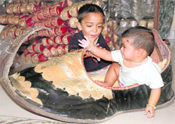 Larger than life: An infant tries to fit into a giant Punjabi jutti in Patiala