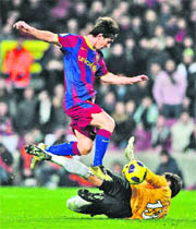 Barcelona's Argentinian forward Lionel Messi (blue) vies with Real Betis' goalkeeper Casto Espinosa (yellow) during the Copa del Rey (King's Cup) football at the Camp Nou stadium in Barcelona on Wednesday.