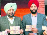 Officials of the State Special Operation Cell display fake currency notes seized from a smuggler in Amritsar on Friday.