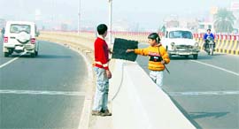 Children grab a kite as it falls in the middle of a flyover in Amritsar on Thursday.