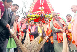 Chief Minister Ramesh Pokhriyal Nishank and other BJP leaders sweep the road ahead of the start of the Jagannath yatra in Dehradun on Friday