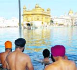 Devotees take a holy dip in the sarovar of the Golden Temple on the occasion of Makarsankranti on Friday.