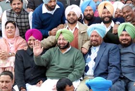 Former CM and PPCC chief Amarinder Singh waves to the gathering during the Congress political conference at Maghi Mela in Muktsar on Friday. Also seen in the picture are CLP leader Rajinder Kaur Bhattal (extreme left) and other party leaders.