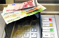 A picture illustration of Euro banknotes is seen at an ATM in Berlin on Saturday. Starting Saturday, teller machines in Germany must display the transaction fees to customers who are not clients of the bank, according to a new law