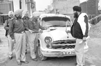 Police officials challan a person illegally using red beacon atop his Ambassador car in Zirakpur 